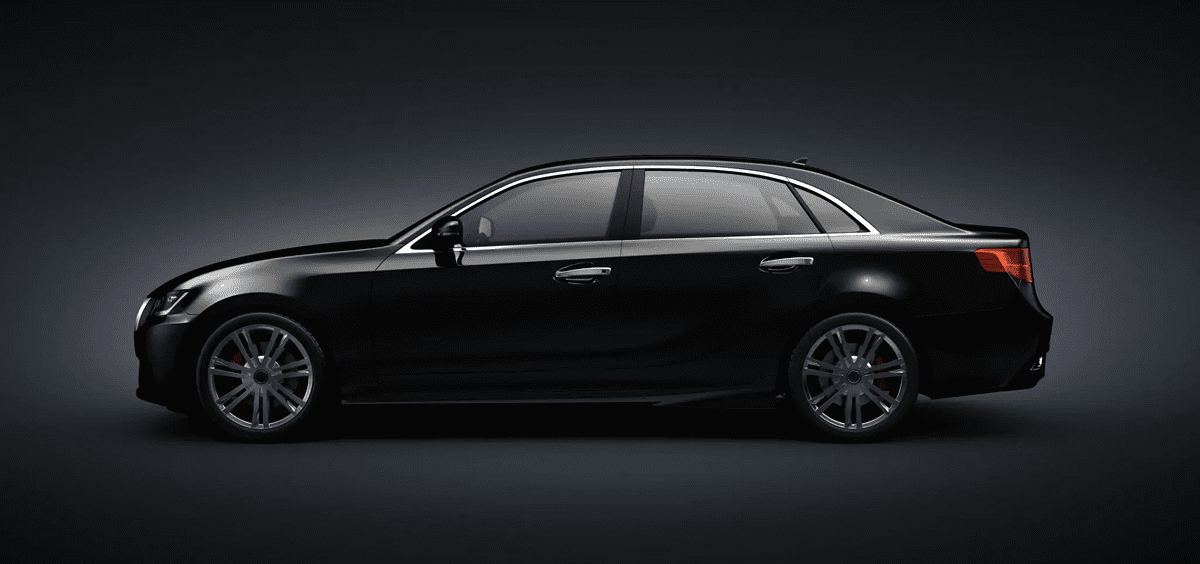 Black midrange sedan in side profile on a dark studio background.